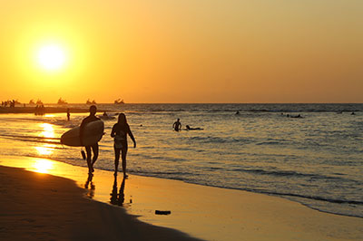 Happy couple surfing at Mancora beach