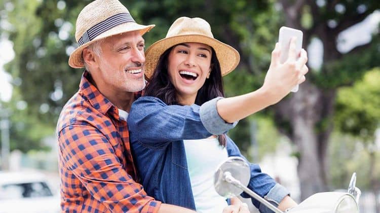 a happy couple on their motorcycle taking a selfie