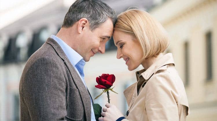 an older man giving a rose to his date