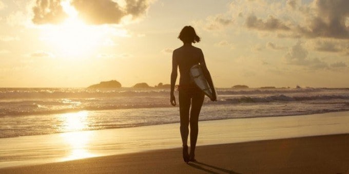 girl in the shore with surfing board