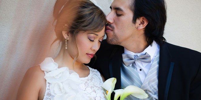 man kissing his wife on the forehead