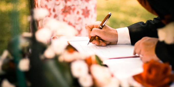 man signing marriage certificate