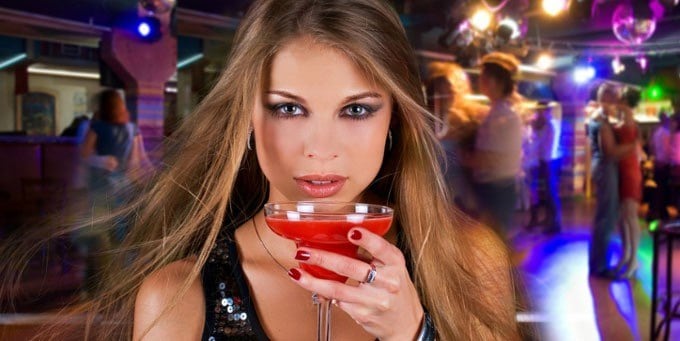 young woman at the bar drinking cocktail