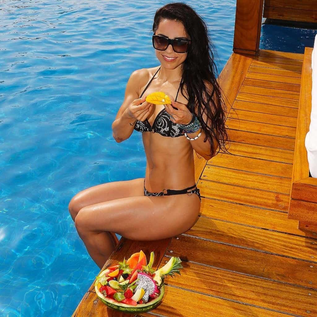 Andreia Brazier eating fruit by the pool