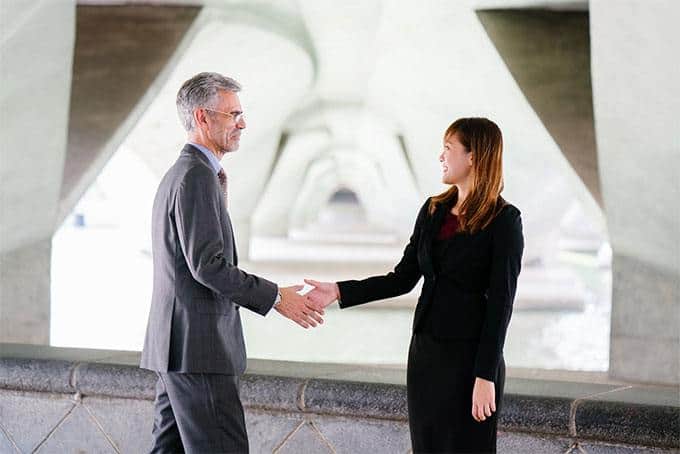 young woman and old guy having a handshake