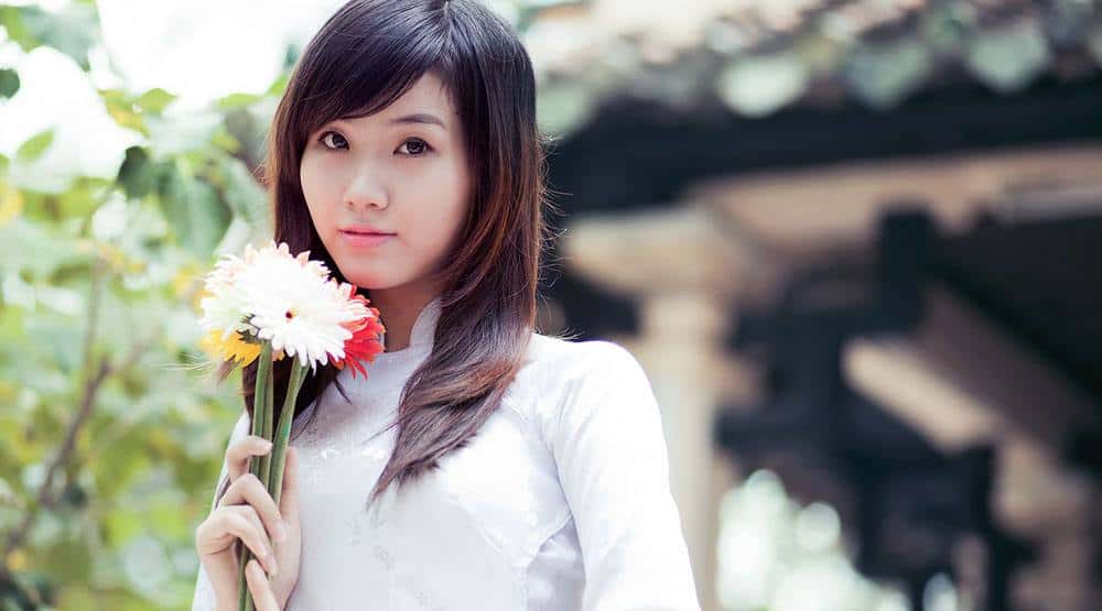 lovely Vietnamese babe holding beautiful flowers