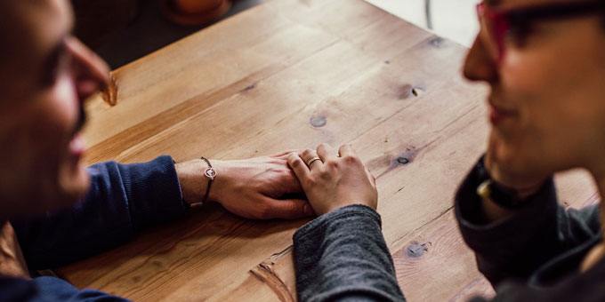 woman holding a man's hand in a cafe