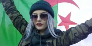 Cute Algerian woman holding a flag