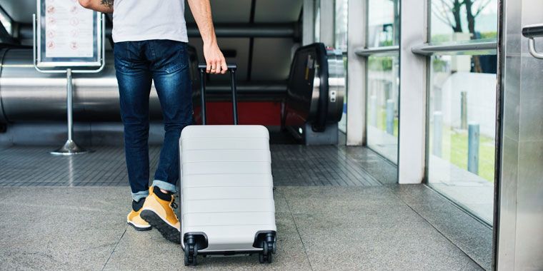 man holding a rolling luggage