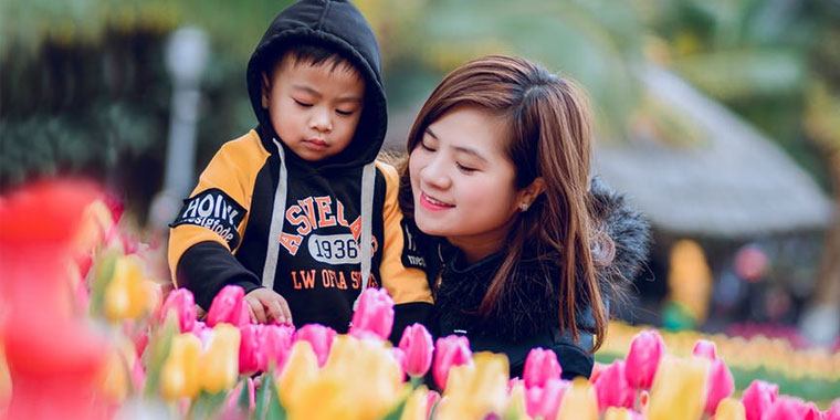 mom and child in front of flowers