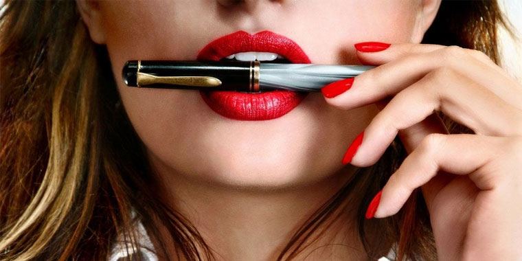 woman with red lipstick biting on a pen