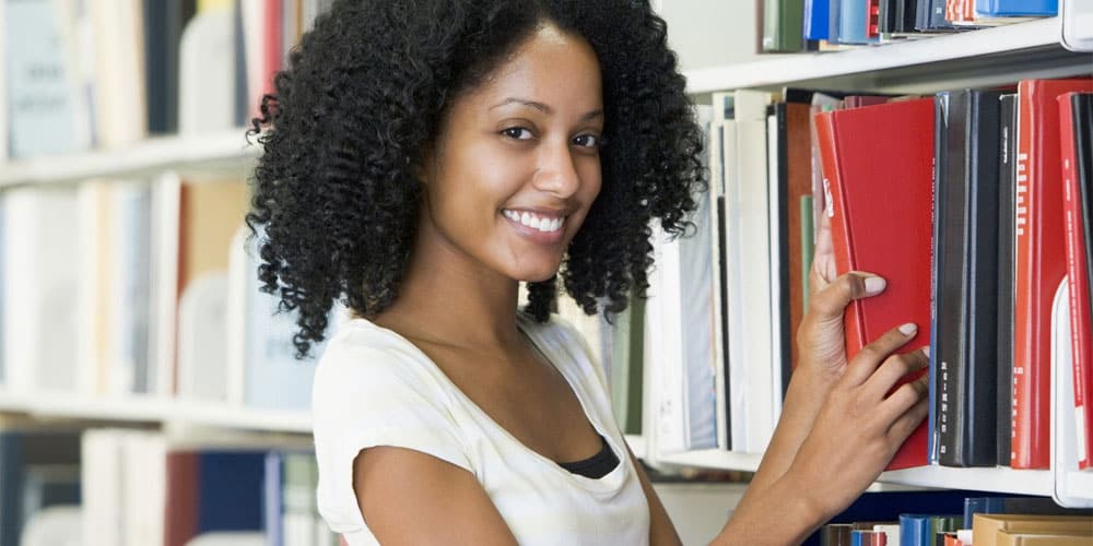 cute-black-woman-getting-book-in-the-library