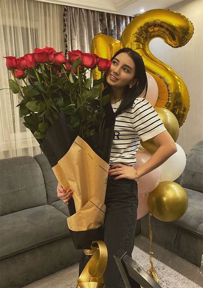Aynur Toleuova holding a large bouquet of roses