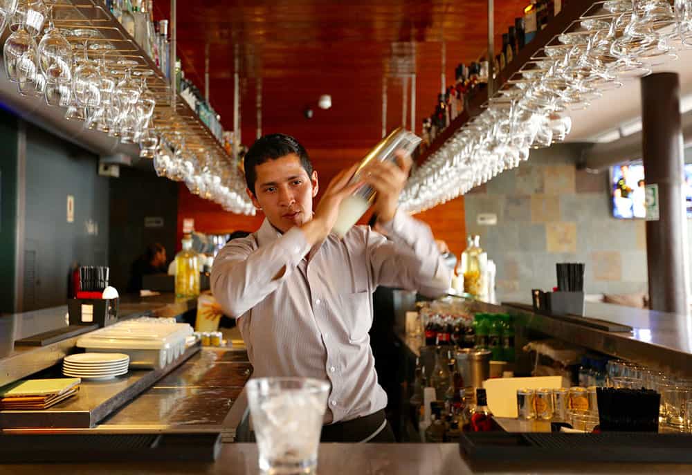 bartender in Lima, Peru mixing Pisco Sour drink